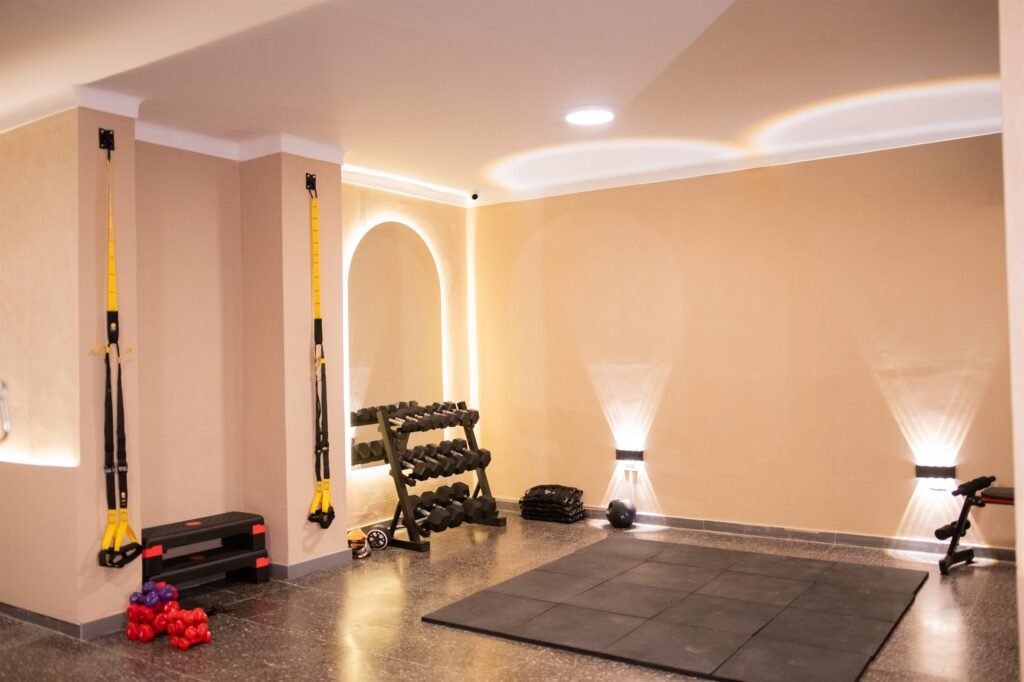 Espacio de entrenamiento con mancuernas y espejo en arco en 50 Wellness Center