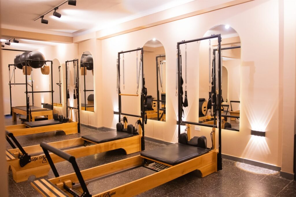 Reformers con torre y espejos en arco en 50 Wellness Center